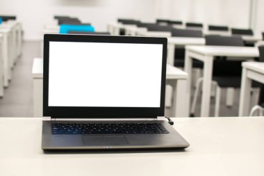 Dizüstü bilgisayar, online iş, öğretmen sınıfta çalışır. Dizüstü bilgisayar bir masaya veya masaya konur