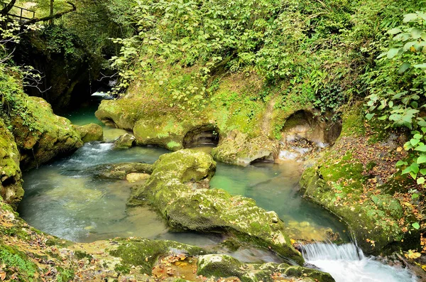 The rough mountain river flows among the stone banks