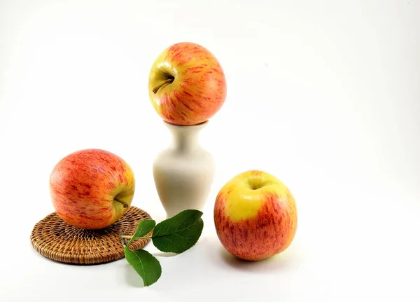 Два Спелых Яблока Подставке Соломы Глиняная Ваза Белом Фоне — стоковое фото