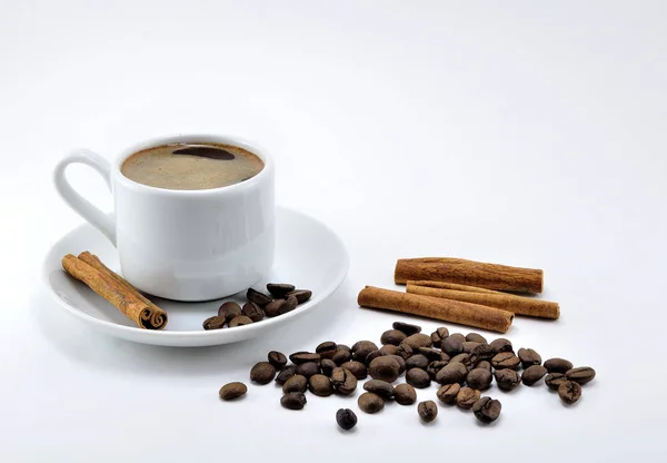 Beyaz porselen fincan şeker ve tarçın, beyaz bir arka plan üzerinde siyah kahve.