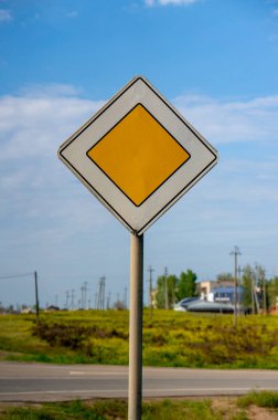 Bulutlu bir günde yol kenarında ana yol işareti