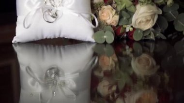 Alyans buket yakınındaki beyaz bir yastık üzerinde.