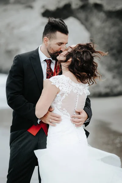 Gelin ve damat sahilde yürüyor. Panoramik görünümü. Sarılma.