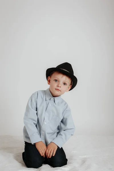 El chico con un sombrero negro y una camisa ligera —  Fotos de Stock