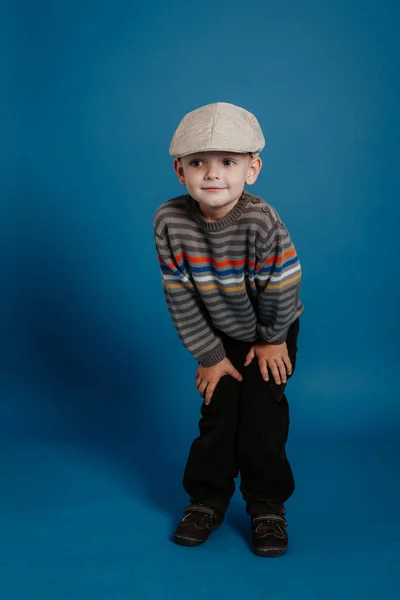 Маленький хлопчик в шапці позує і посміхається . — стокове фото