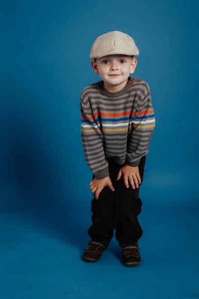 Un bambino con un berretto posa e sorride . — Foto Stock