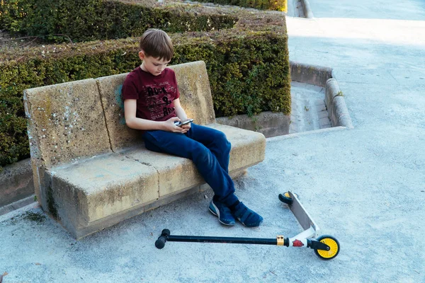 Çocukların modern sorunları. Çocuk parkta telefonla oynuyor..