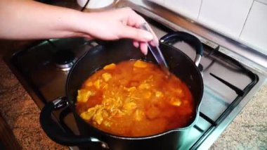 Yavaş pişirilmiş domates soslu et. Kadın ete domates sosuna kıpırdanırken..