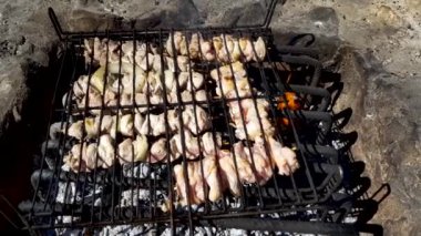 Izgara, kızarmış et, tavuk ızgara, sosis, kebap, hamburger, sebze, barbekü, deniz ürünleri. Izgara biber ve soğan. Yakın çekim güneşli açık hava Şef ızgaradaki eti çeviriyor