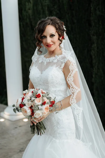 Stunning young bride holding wedding bouquet.