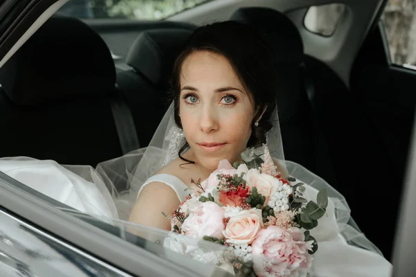 Gelin düğün arabada oturur. bir araba penceresinde gelin — Stok fotoğraf