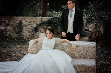 Düğün çifti. Gelin oturuyor. Damat duruyor