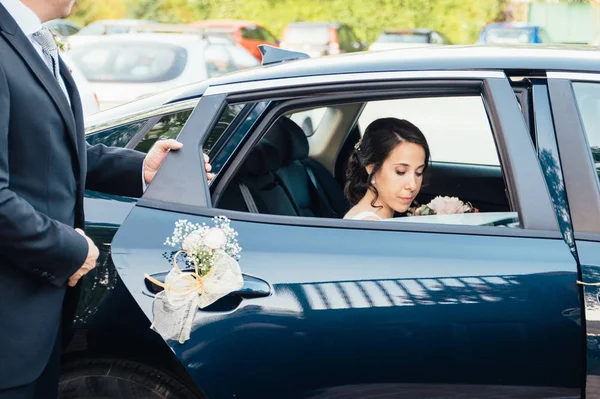 Papa öffnet der Braut die Autotür. — Stockfoto