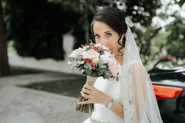 Gelin gelinlik ve holding beyaz buket peçe gülümseyen