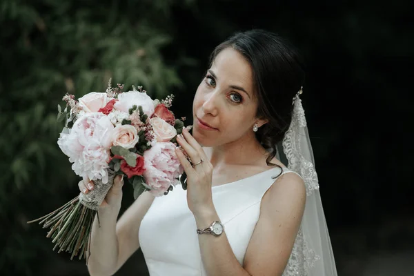 Šťastná a usměvavá nevěsta v luxusních šatech se svatební kyticí — Stock fotografie