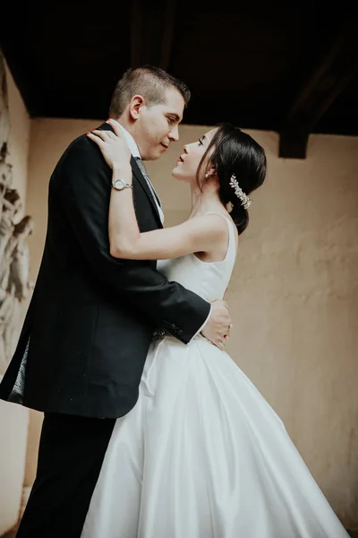 Frischvermählte umarmen sich und schauen einander an. Braut und Bräutigam umarmen sich. — Stockfoto