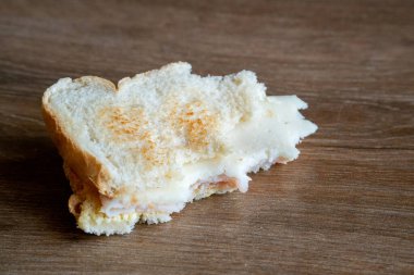 Yere atılmış yarısı yenmiş sandviçler. Atılmış Sandviç. Ekmek yere fırlatıldı. Çöpe atılmış yiyecekler. Kavram