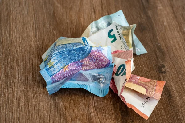 Beş para etmez. Ahşap bir arka planda buruşuk euro parası. Enflasyon döneminde para. Buruşmuş Banknotlar