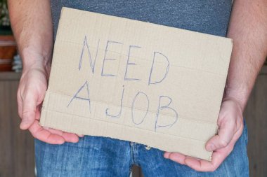 Kot pantolonlu adam elinde bir karton tutuyor. Bir işe ihtiyacım var. Görev Araması Konsepti