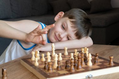 Satranç oynayan çocuklarla eğlenceli bir oyun. Çocuklarla masa oyunu oynamak.