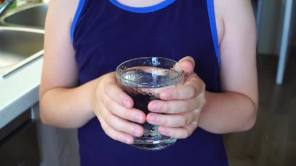 Mignon garçon eau potable sur la cuisine — Video