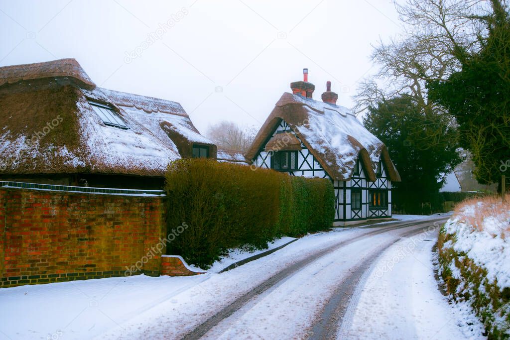 Winter snow covered thatched cottage in England