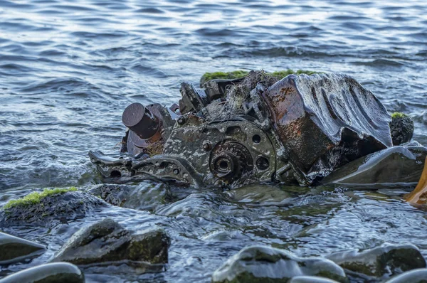 물 속에 돌 사이에 누워 있는 오래된 녹슨 엔진 — 스톡 사진