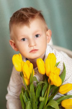 Bahar çiçek buketi mavi izole kamera bakıyor tatlı gülümseyen hamile. Küçük yürümeye başlayan çocuk için anne hediye olarak Sarı laleler holding