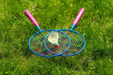 Çimlerin üzerinde badminton raketleri vardı.