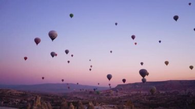 Goreme, Türkiye 'de vadilerde uçan sıcak hava balonları. Dünyanın her yerinden turistler sıcak hava balonlarıyla seyahat etmek için Cappadocia 'ya geliyorlar..