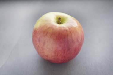 gri zemin üzerine kırmızı elma