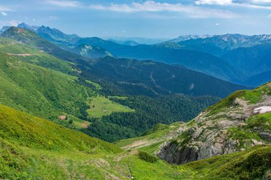 Bir açık yaz gününde yüksek dağlarla çevrili yeşil vadi üzerinde görüntüleyin. Krasnaya Polyana, Sochi, Rusya Federasyonu.