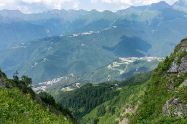 Konut evler, yüksek dağlarla çevrili vadinin tepelerden görüntüleyin. Krasnaya Polyana, Soçi, Kafkasya, Rusya Federasyonu.