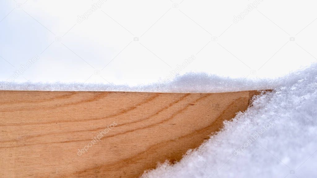 Birch board sprinkled with fresh white snow. Copy space background