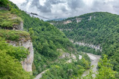Bizimhava asma köprü üzerinde bir uçurumun ve bulutlu bir günde nehirde. Skypark, Sochi, Rusya Federasyonu.