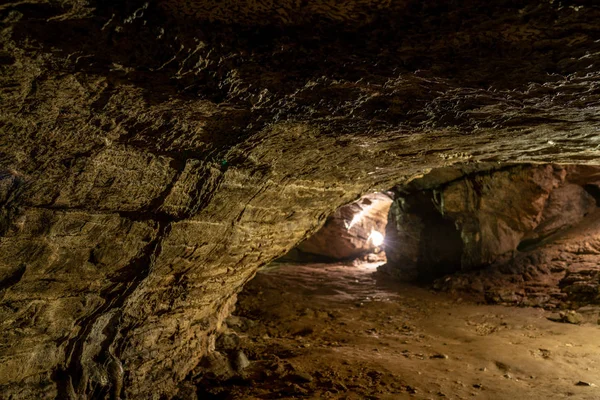 Ek aydınlatma ile taş duvarlar ile eski mağara içinde görüntüleyin. Bir mağarada taştan bir duvar dokusu. Akhshtyr Mağarası, Sochi, Rusya Federasyonu