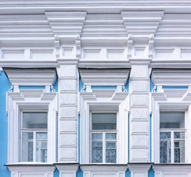 Mavi ve beyaz duvarlı eski 19. yüzyıl konağının üç pencere