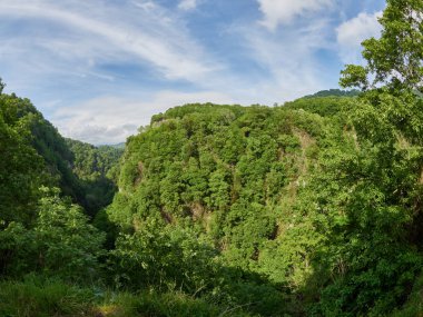 Yeşil ormanıyla kaplı dağları arasında aşağı bir nehir ile geçit.