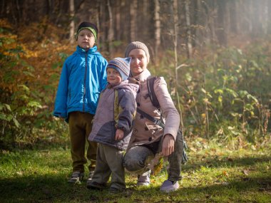 Anne iki çocuklu autumn ormanda yürüyüş