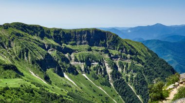 Dağ kayalar ve açık mavi gökyüzü karşı ağaçlar.