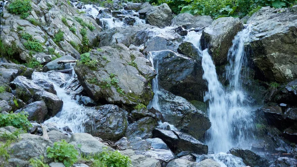 Un poderoso arroyo de montaña desciende de las rocas y piedras . — Foto de Stock