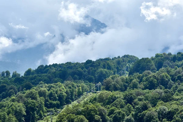 Pista de montaña verde con teleféricos y pistas de esquí en un día nublado de verano — Foto de Stock
