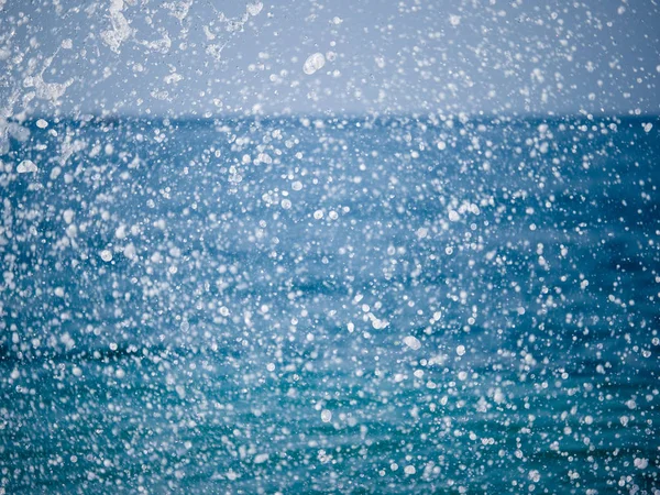 Salpicaduras de agua contra el mar en un soleado día de verano — Foto de Stock