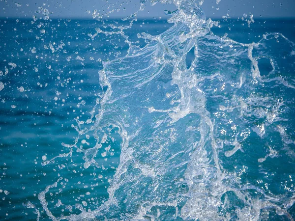 Salpicos de água contra o mar em um dia ensolarado de verão — Fotografia de Stock
