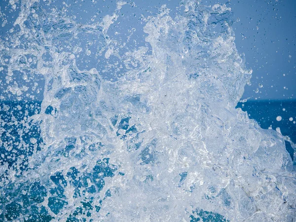 Des éclaboussures d'eau contre la mer par une journée d'été ensoleillée — Photo