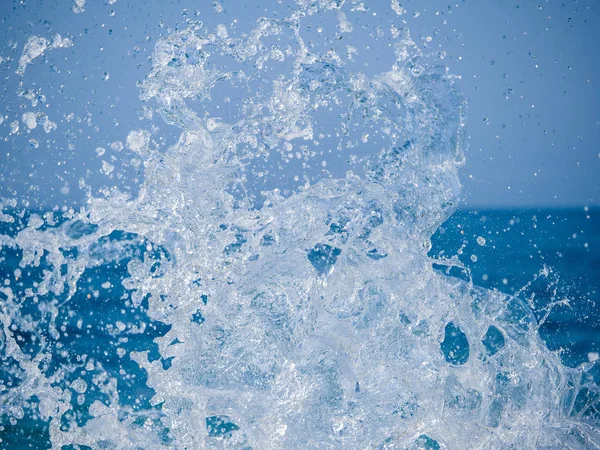 Des éclaboussures d'eau contre la mer par une journée d'été ensoleillée — Photo