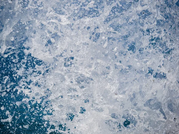 Salpicaduras de agua contra el mar en un soleado día de verano — Foto de Stock