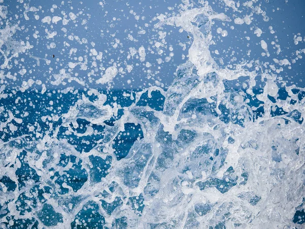 Salpicos de água contra o mar em um dia ensolarado de verão — Fotografia de Stock