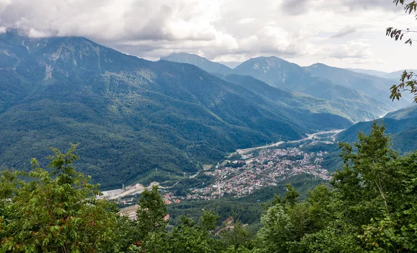 Dorf in einem Bergtal inmitten des grünen Waldes. — Stockfoto