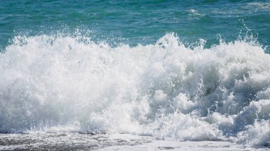 Güneşli bir yaz gününde denize karşı su dalgaları ve sıçramaları